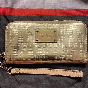 Reflective gold Michael Kors wristlet.